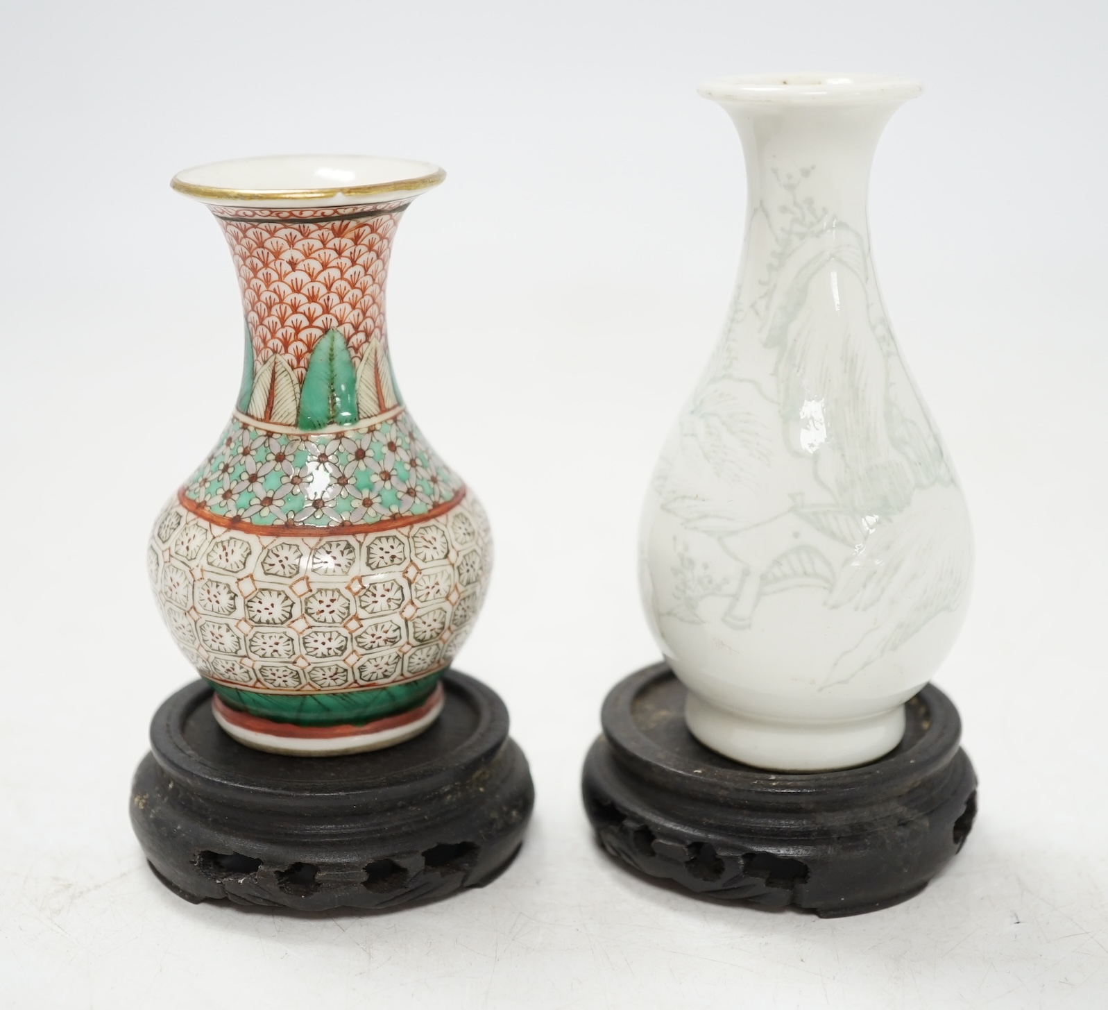 Two miniature Chinese porcelain vases, on hardwood stands, largest 9cm high. Condition - fair